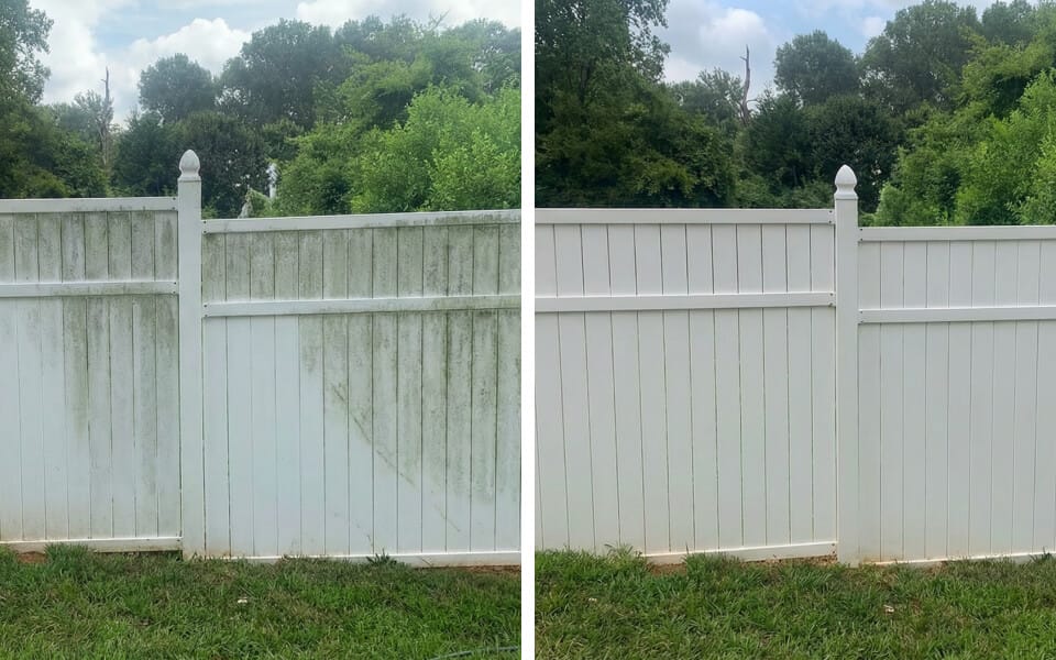 Side-by-side comparison of a white fence; the left side is stained with green mildew, while the right side appears clean and bright. Trees and grass are visible in the background.